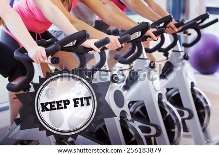 The word keep fit and mid section of people working out at spinning class against badge