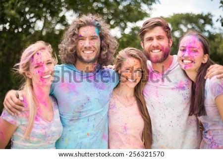 Happy friends covered in powder paint on a sunny day