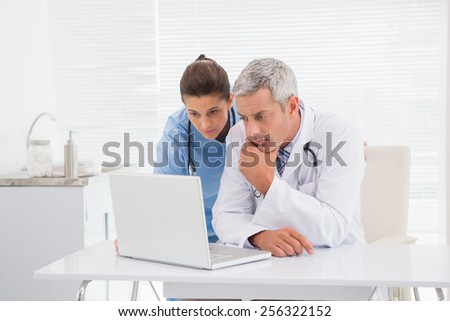 Doctors looking at laptop in medical office