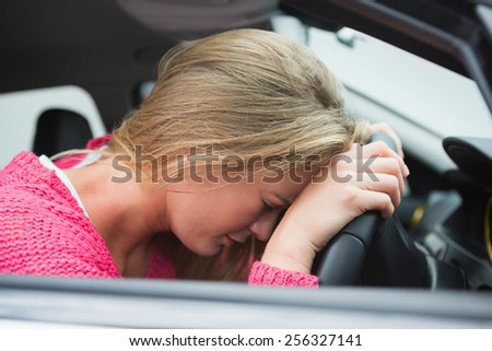 Unhappy young woman in her car
