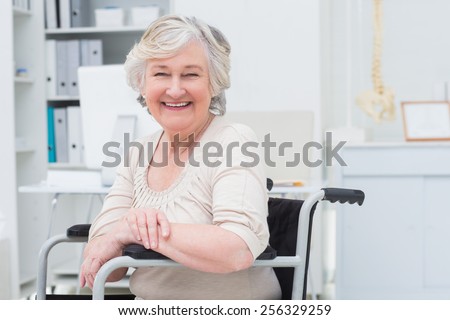 Portrait of happy senior woman sitting on wheelchair in clinic
