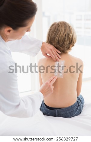 Doctor testing a childs skin in her office