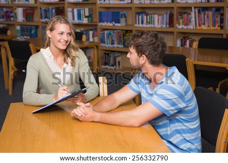 Student getting help from tutor in library at the university