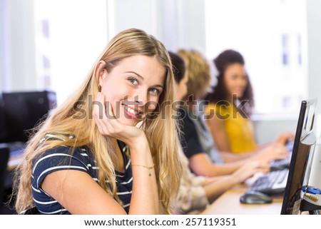 Female student smiling at camera in computer class