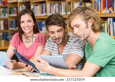 Group of college students using digital tablets in the library