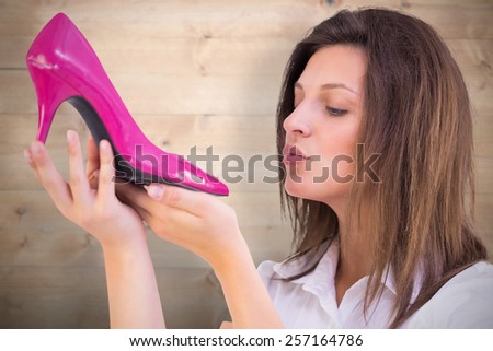 Close up of a young woman about kissing a shoes against bleached wooden planks background