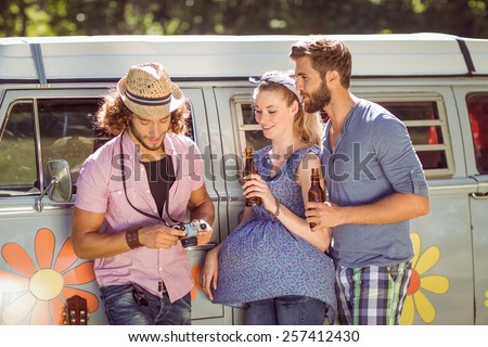 Hipster friends chatting and drinking on a summers day