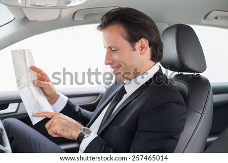 Businessman reading a map in his car