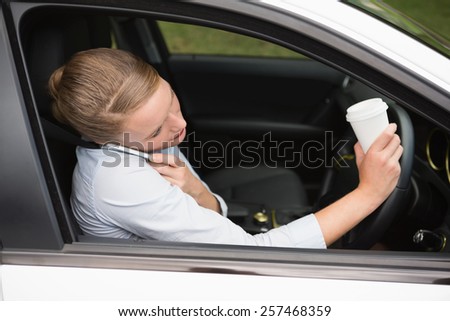 Young businesswoman having a coffee in her car