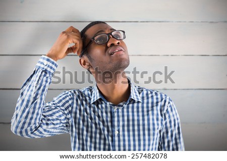 Young businessman thinking scratching head against painted blue wooden planks