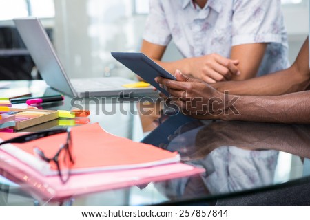 Close up of creative young business people with digital tablet at office desk