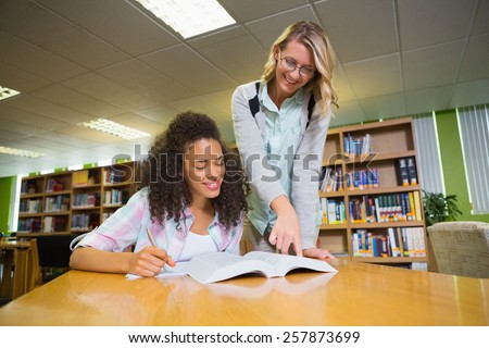 Student getting help from tutor in library at the university
