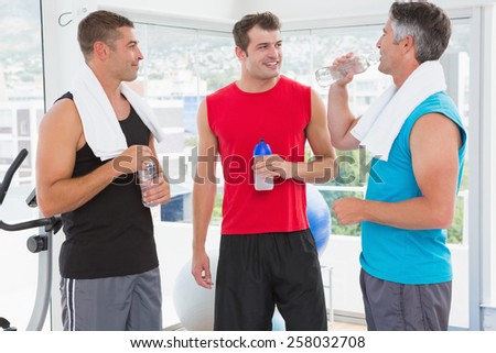 Group of smiling men talking each other in fitness studio