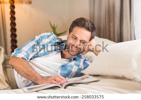 Handsome man relaxing on his bed at home in bedroom