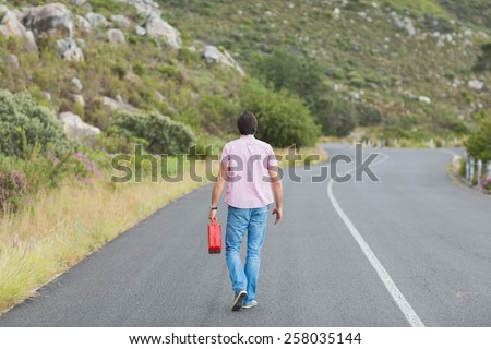 Man walking away holding petrolcan at the side of the road