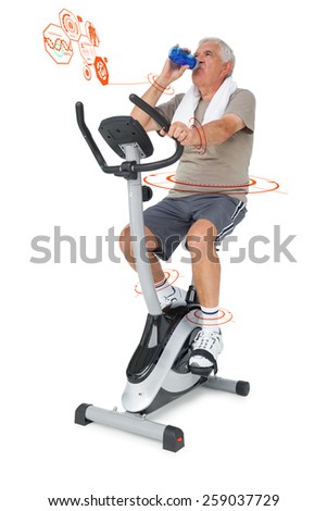 Senior man drinking water on stationary bike against fitness interface