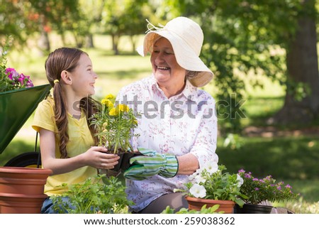Happy grandmother with her granddaughter gardening on a sunny day