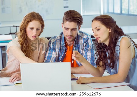 Fashion students looking at laptop at the college