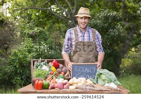 Happy farmer showing his produce on a sunny day
