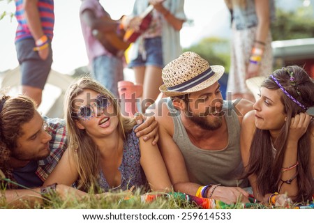 Happy hipsters chatting on the campsite at a music festival