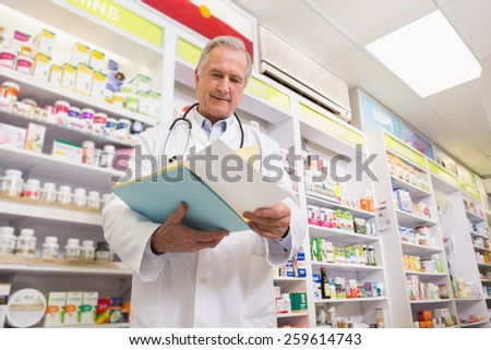 Smiling doctor reading a prescription in the pharmacy