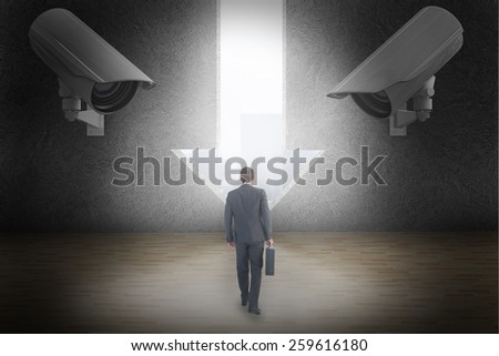 Businessman walking with his briefcase against light bulb graphic on futuristic blue background