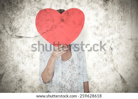 Woman holding heart card against grey background
