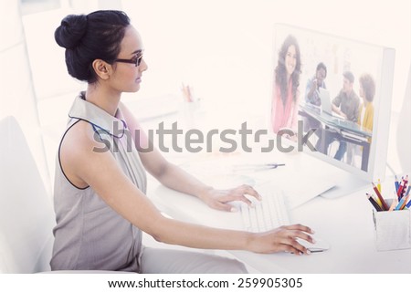 Composite image of smiling designer using tablet in office