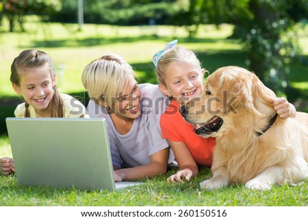 Happy family looking at their dog on a sunny day