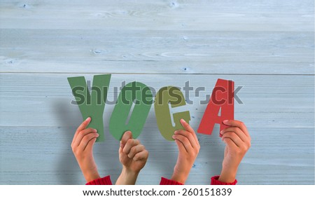 Hands holding up yoga against bleached wooden planks background