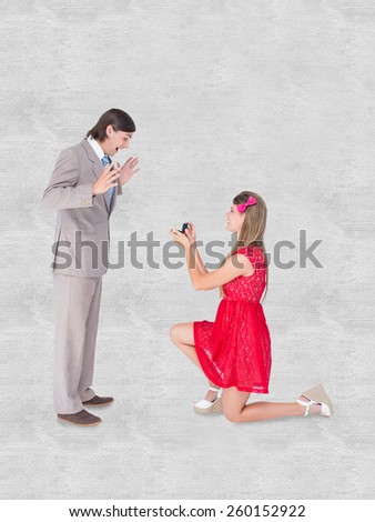 Pretty hipster on bended knee doing a marriage proposal to her boyfriend against white background