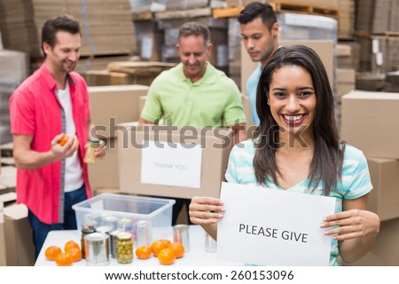 Warehouse workers packing up donation boxes in a large warehouse