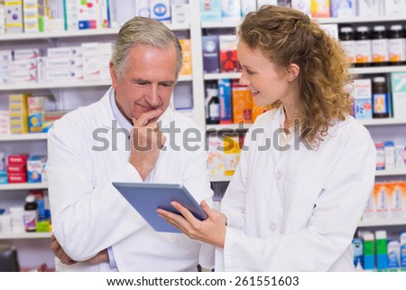 Team of pharmacist looking at tablet pc at hospital pharmacy