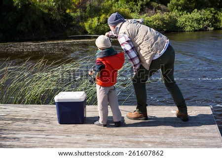 Happy man fishing with his son in the countryside