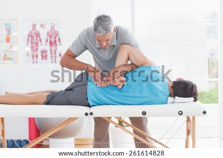 Doctor examining man back in medical office