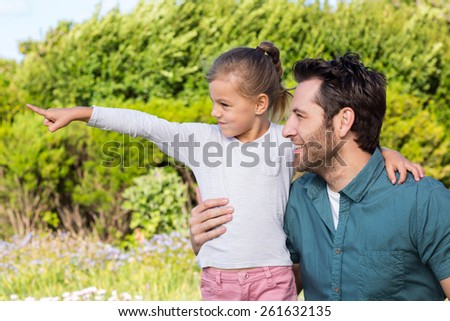 Father and daughter looking at something in the countryside