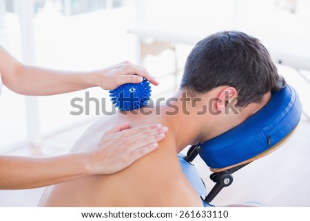 Man having back massage with massage ball in medical office