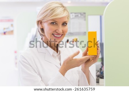 Pharmacist showing medicine jar at the hospital pharmacy