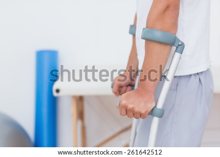 Patient standing with crutch in medical office