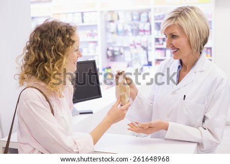 Pharmacist giving medicine to costumer at pharmacy