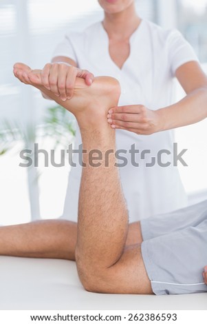 Physiotherapist doing leg massage to her patient in medical office