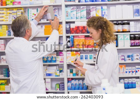 Pharmacists searching medicines with prescription at hospital pharmacy