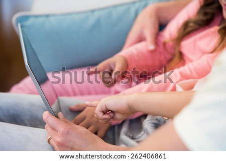 Family on the couch together using tablet pc at home in the living room