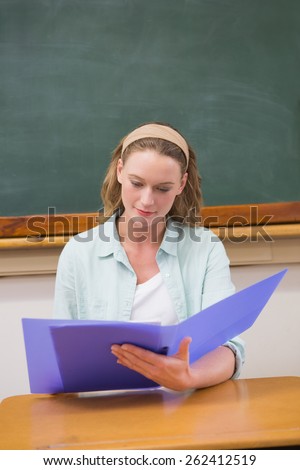 Teacher reading papers at her desk at elementary school