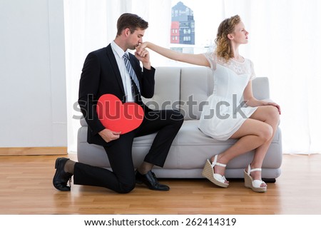 Businessman kissing his girlfriend hand on the living room