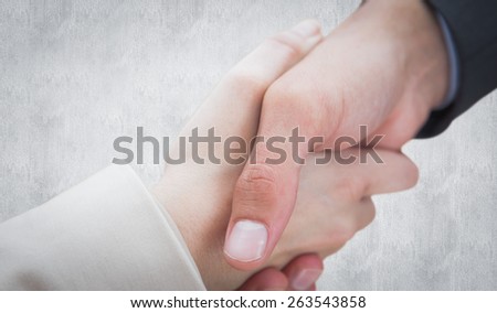 Close up on new partners shaking hands against white background