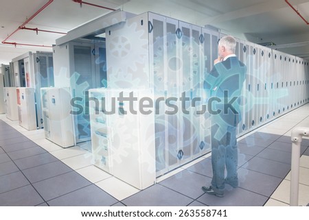 Thoughtful businessman standing back to camera against data center