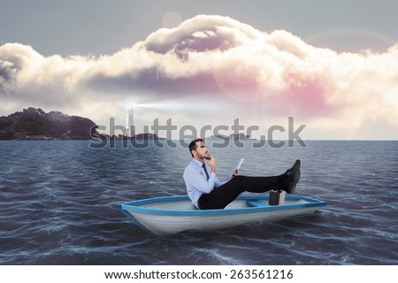Businessman in boat with tablet pc against calm sea with lighthouse