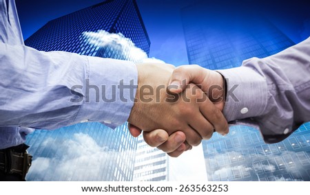 Two men shaking hands against low angle view of skyscrapers
