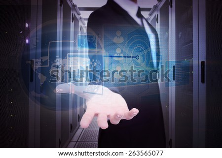Smiling businessman offering something with his open hand against data center